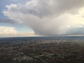 Aerial view of cityscape against cloudy sky