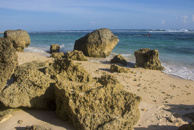 Rocks on beach against sky