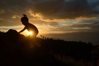 Silhouette man against sea during sunset