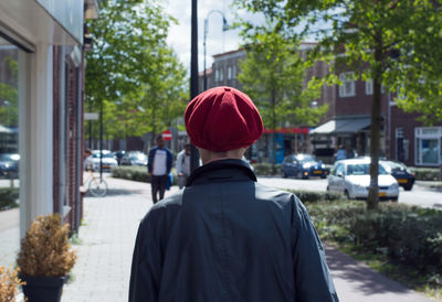 Rear view of woman standing on sidewalk