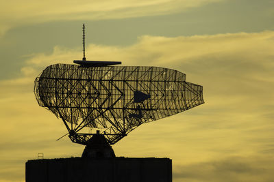 Low angle view of weather vane against sky during sunset