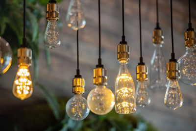 Low angle view of illuminated light bulbs hanging from ceiling