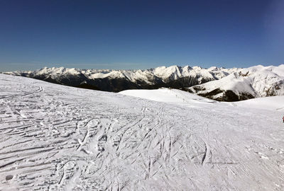 Scenic view of snowcapped mountains against clear blue sky