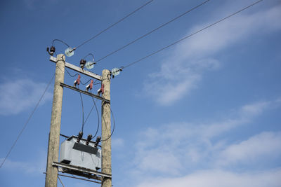 Low angle view of telephone pole against sky