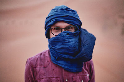 Young man wearing a headscarf in the desert