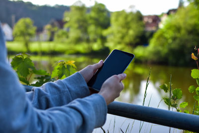 Midsection of man using mobile phone