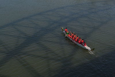 High angle view of people sitting on rowboat in river