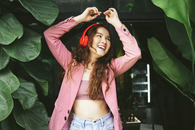 Portrait of smiling young woman standing in park