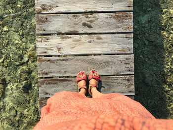 Low section of woman standing on footpath