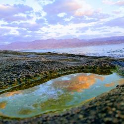 Scenic view of sea and mountains against sky