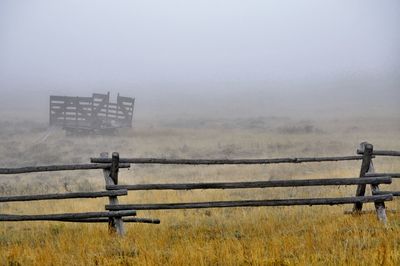 Fence on field in foggy weather