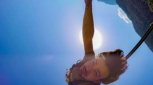 Low angle view of woman against clear blue sky