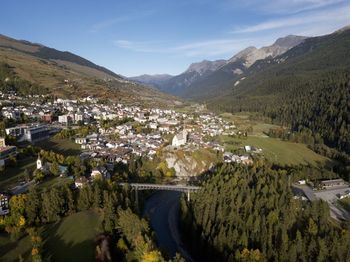 Scenic view of townscape by mountains against sky