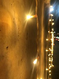 Close-up of illuminated lights against sky at night