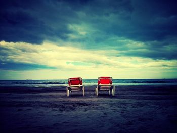 Scenic view of beach against cloudy sky