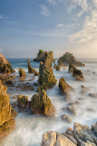 Scenic view of rocks on beach against sky