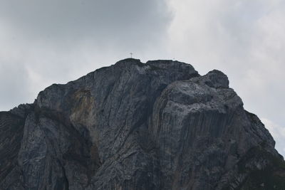 Low angle view of rock formation against cloudy sky