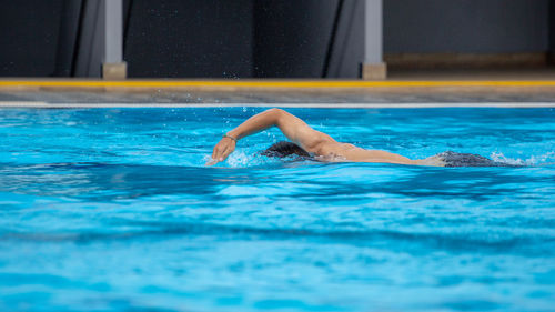 Side view of man swimming in pool