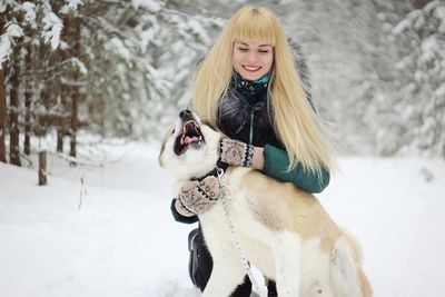 Young woman with dog on snow