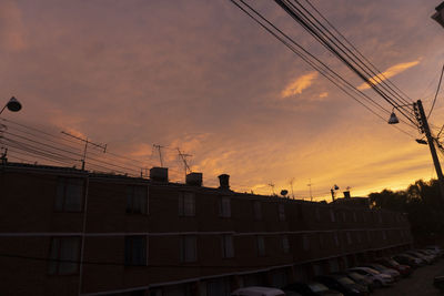 Low angle view of silhouette buildings against sky at sunset