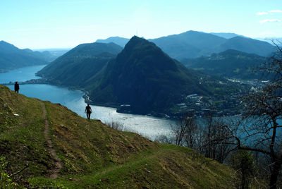 Hikers standing on mountain against sky