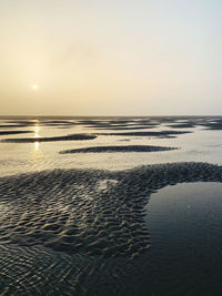 Scenic view of beach against sky during sunset