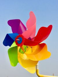 Low angle view of multi colored toy against clear sky ,turbine