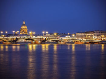 Illuminated bridge over river in city 