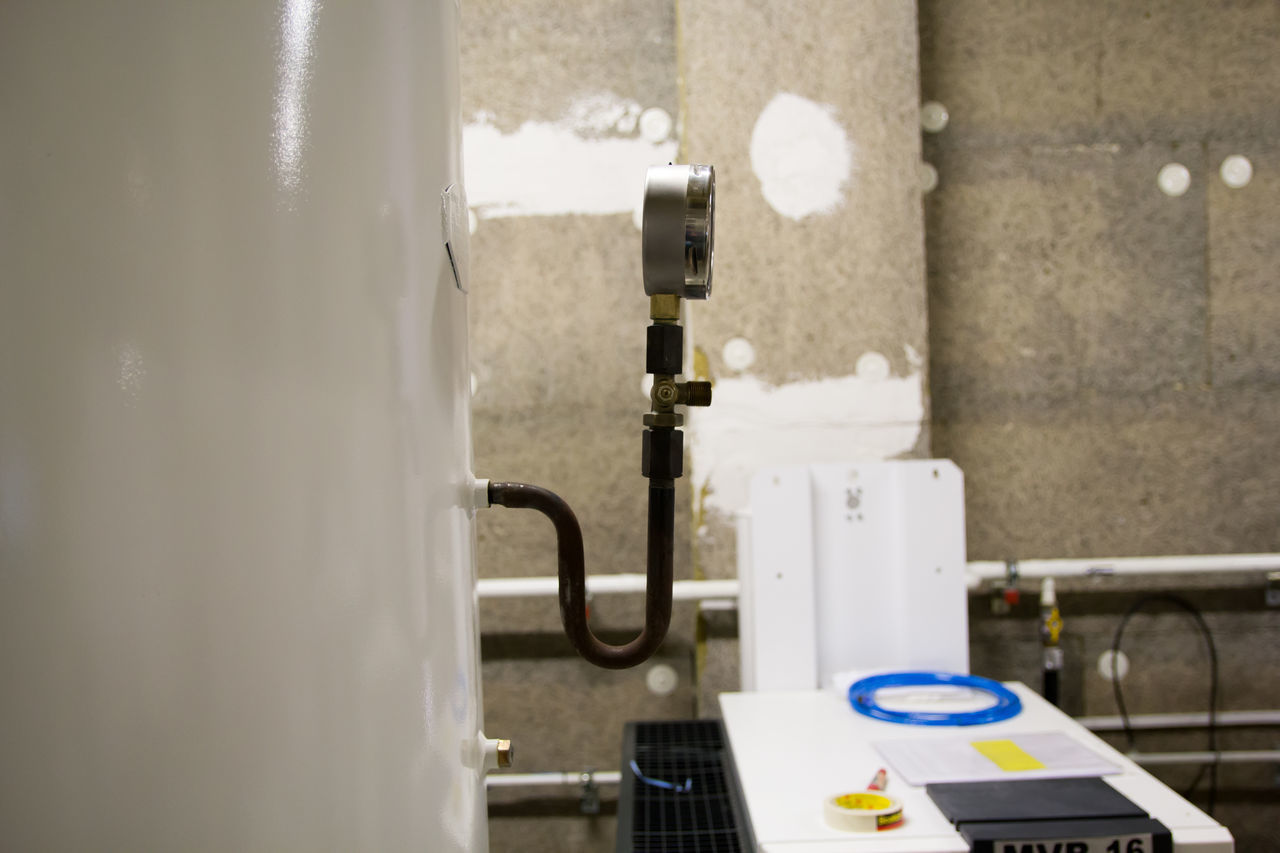 CLOSE-UP OF FAUCET AGAINST WALL