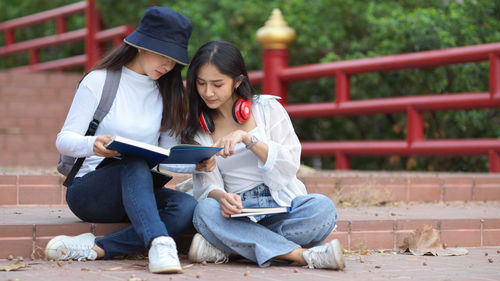 Young woman using mobile phone while sitting outdoors