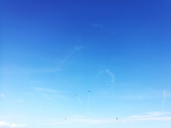 Low angle view of vapor trail against blue sky