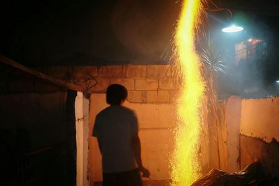 Rear view of woman standing at night