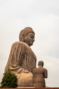 Low angle view of statue against temple against sky