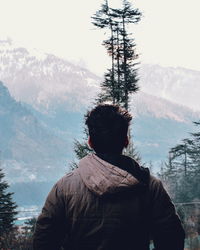 Rear view of man standing on snow covered mountain