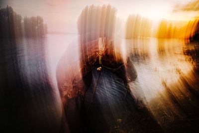 Digital composite image of woman standing by water