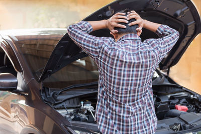 Midsection of man standing in car