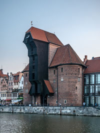 View of old building by river against sky