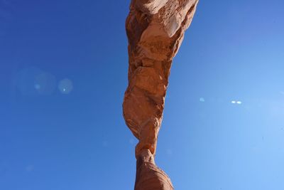 Low section of man against blue sky