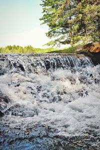 Scenic view of waterfall against sky