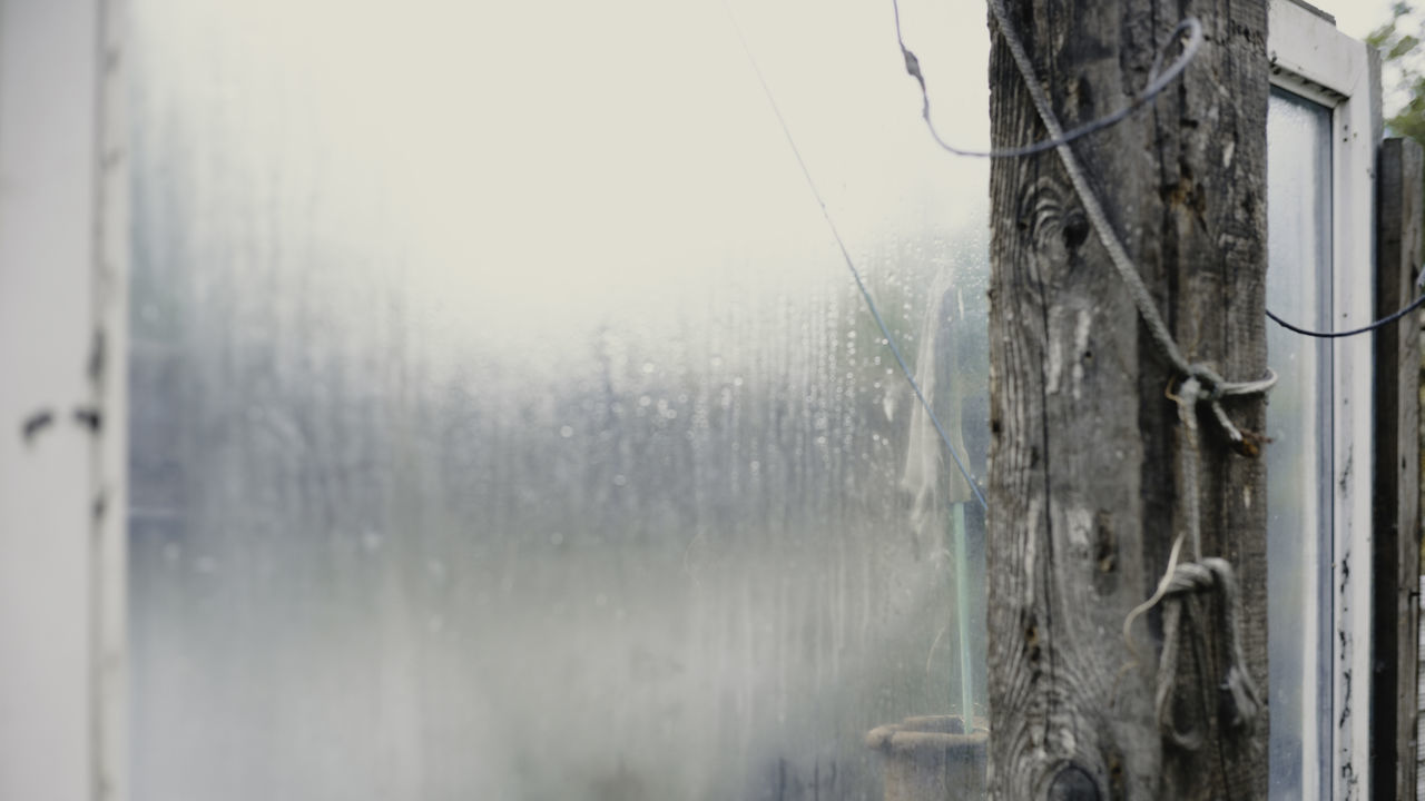 CLOSE-UP OF WET WINDOW IN RAINY SEASON
