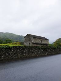 Road by building against sky