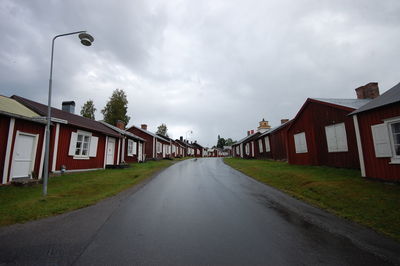 Empty road amidst buildings against sky
