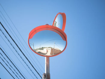 Low angle view of telephone pole against clear blue sky