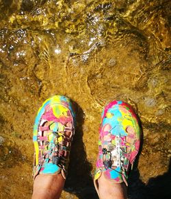 Low section of man standing against multi colored water