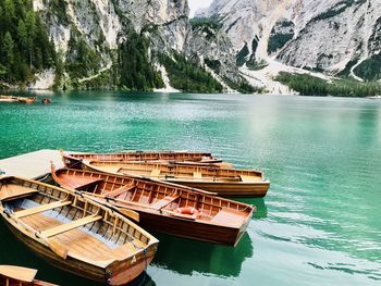 Boats moored in lake against mountains