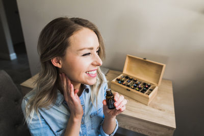 Portrait of smiling young woman using mobile phone at home