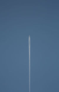 Low angle view of vapor trail against clear blue sky