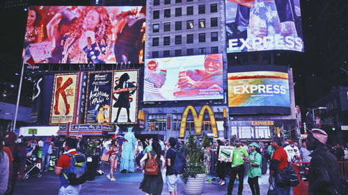 Crowd on street against buildings at night