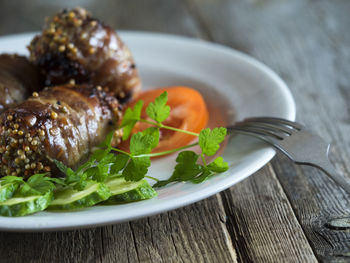 Close-up of raw meatloaf in bacon on wooden table