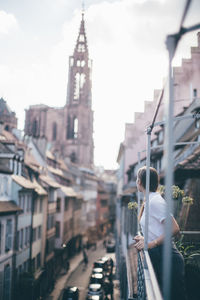 Woman standing in city against sky